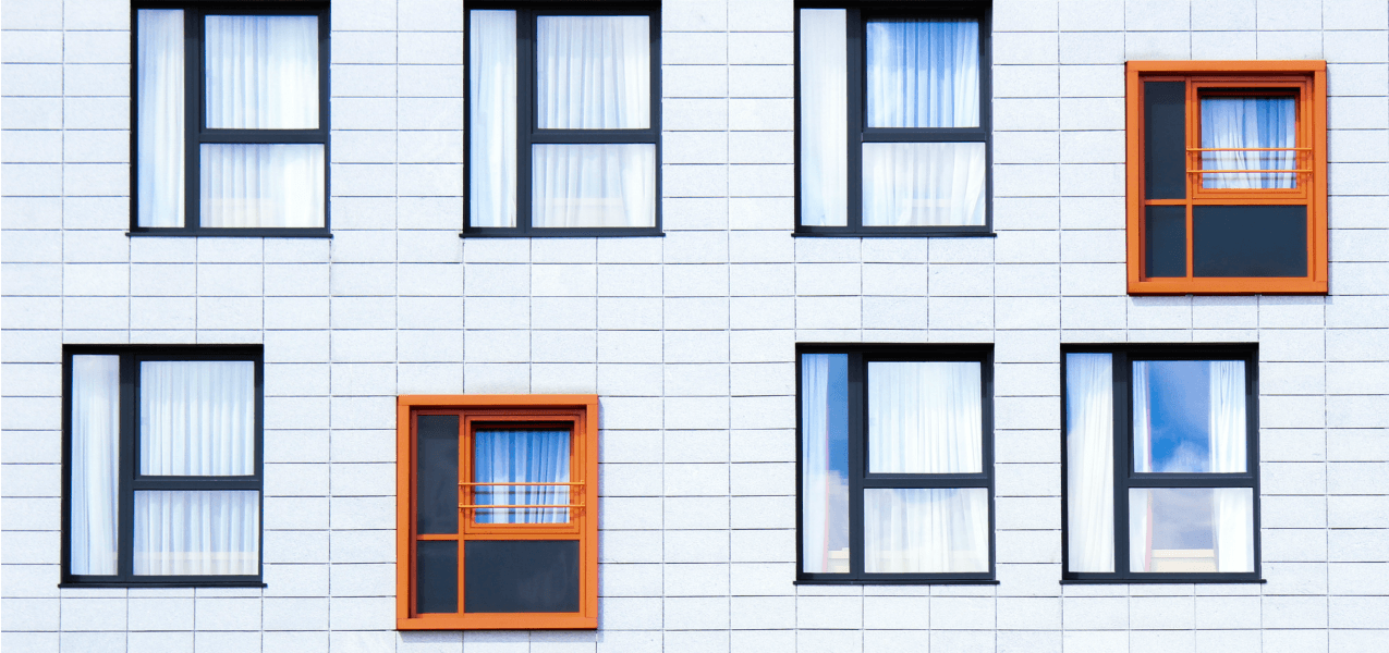 A building with windows with two orange windows.